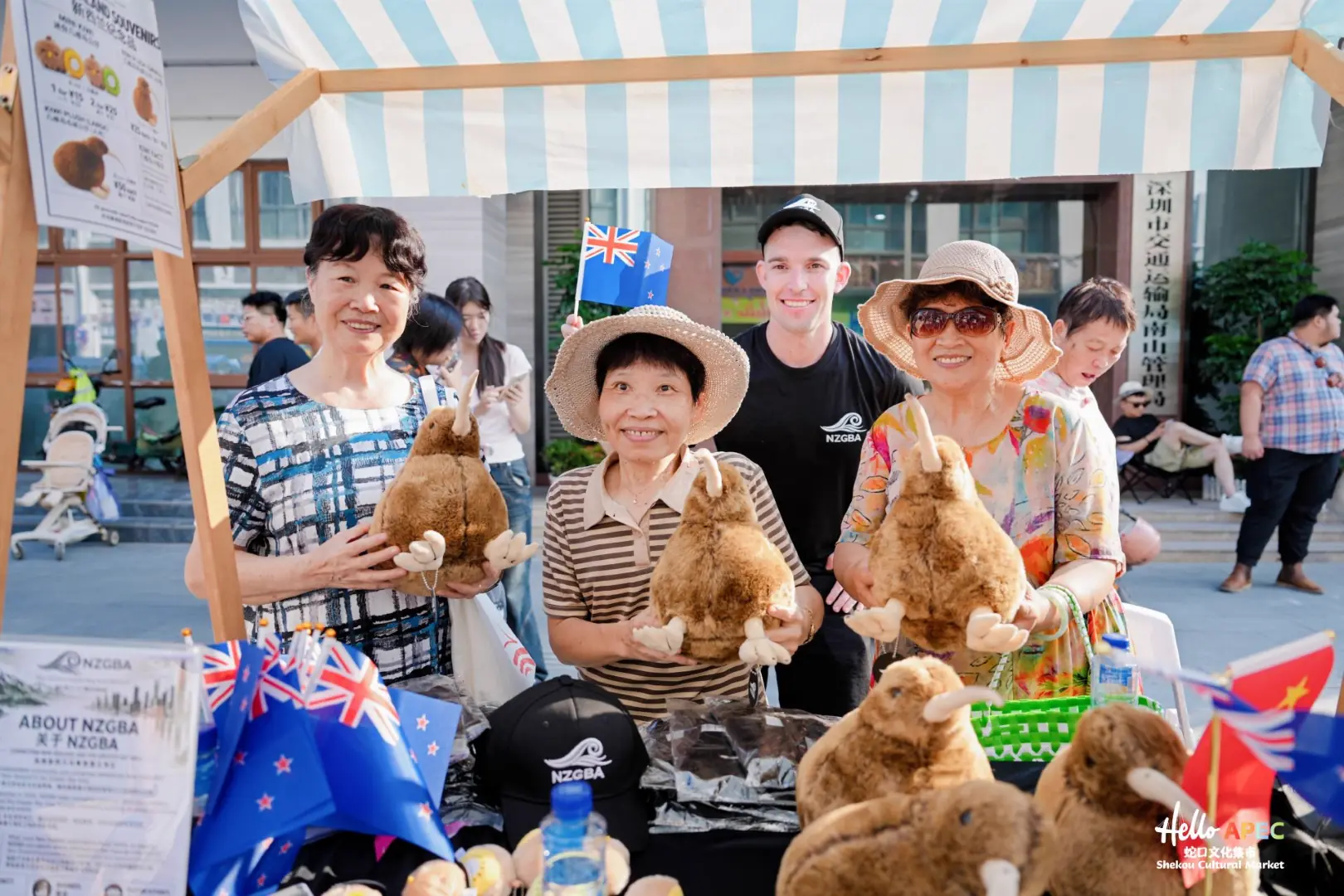Visitors posing with plush kiwi birds at the NZGBA stall