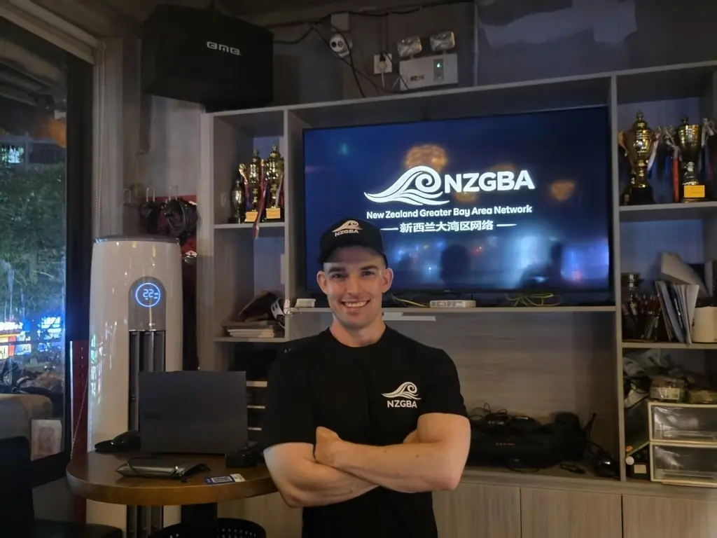 Person wearing an NZGBA shirt beside a presentation screen